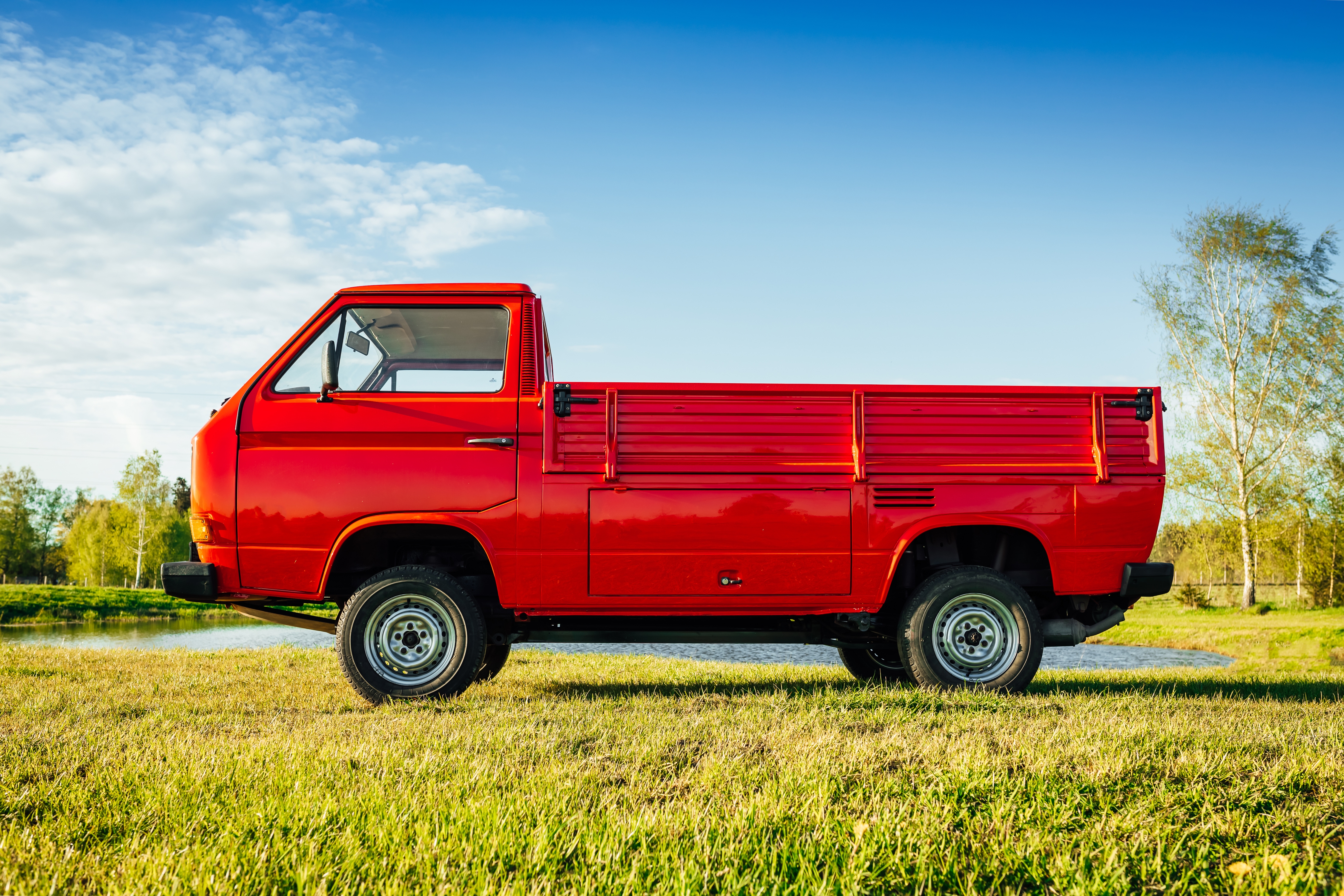 A mini truck parked on a green field. Commercial vehicle loans provided by IndoStar Capital Finance.