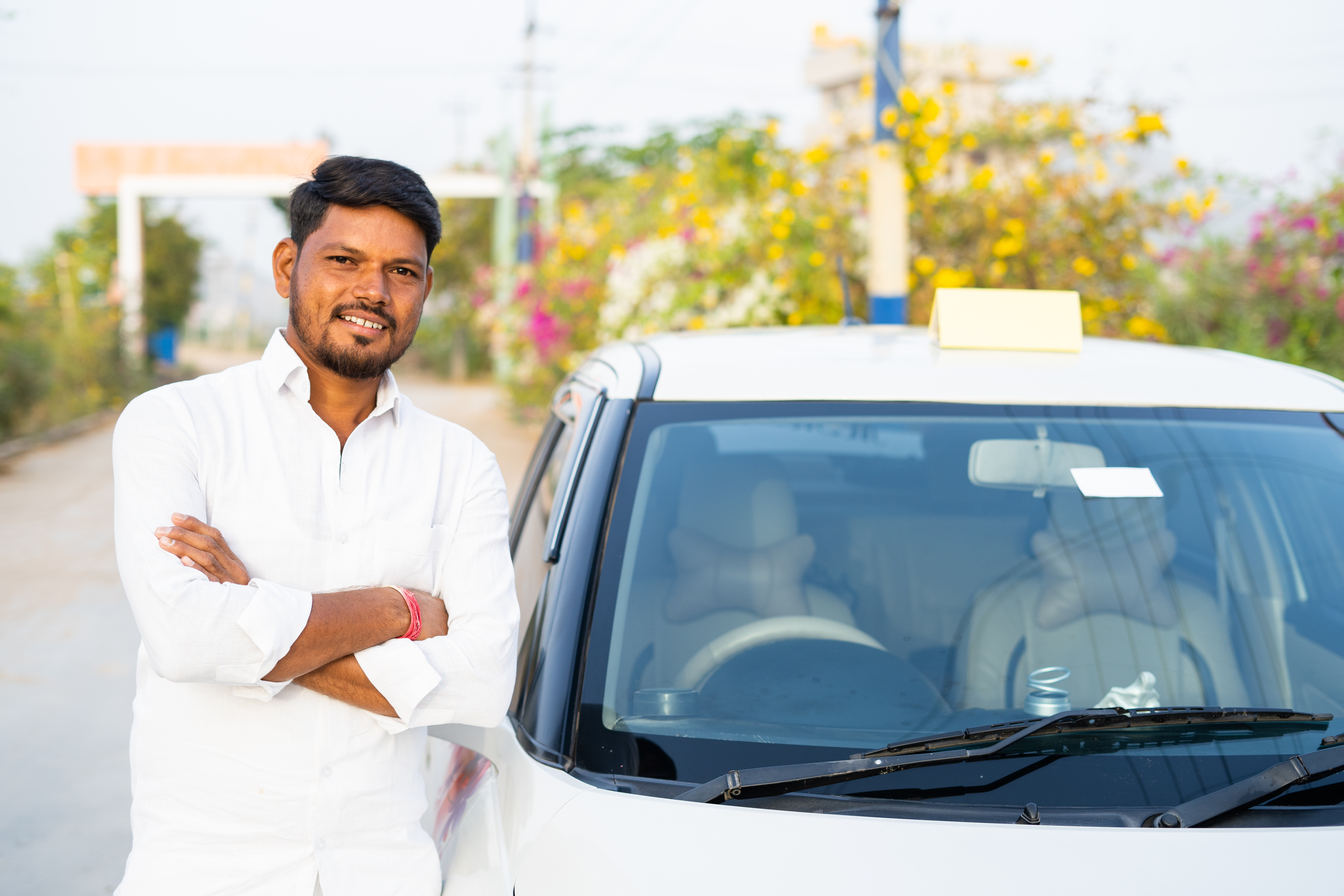 Man standing next to a car. Vehicle Loans provided by IndoStar Capital Finance.